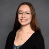 An image of Rachel smiling in front of a plain background.